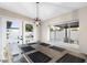 Bright dining area with a modern light fixture and views of the pool through large windows and doors at 10240 N 34Th Pl, Phoenix, AZ 85028