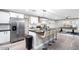 Open-concept kitchen and game room with stainless steel appliances, island seating, and bright lighting at 10240 N 34Th Pl, Phoenix, AZ 85028