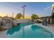 Beautiful pool with a rock waterfall feature, covered patio, and lush landscaping perfect for outdoor entertaining at 10240 N 34Th Pl, Phoenix, AZ 85028