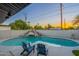 Inviting pool area with comfortable seating, a rock waterfall feature, and lush landscaping for a relaxing outdoor experience at 10240 N 34Th Pl, Phoenix, AZ 85028