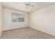 A well-lit bedroom features neutral carpet, a ceiling fan, and a window at 10401 N 108Th Ave, Sun City, AZ 85351