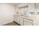 Neutral kitchen design with white cabinets, tile floors, and a bright window at 10401 N 108Th Ave, Sun City, AZ 85351