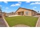 Expansive backyard with a sparkling pool, lush lawn, and covered patio, perfect for outdoor living and entertaining at 10809 W Harmony Ln, Peoria, AZ 85373