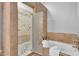 Bathroom with tile shower and tub with decorative tile and neutral-toned walls at 10809 W Harmony Ln, Peoria, AZ 85373