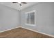 This bedroom features wood flooring and a window with white shutters for natural light at 10809 W Harmony Ln, Peoria, AZ 85373