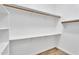 Walk-in closet with white shelving and hanging rods, offering ample storage space at 10809 W Harmony Ln, Peoria, AZ 85373