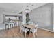 Dining room features chandelier lighting, hardwood floors and an open layout connecting the kitchen and bar seating at 10809 W Harmony Ln, Peoria, AZ 85373