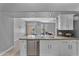 White kitchen island offers stainless steel dishwasher, granite countertop, and views into the dining area at 10809 W Harmony Ln, Peoria, AZ 85373