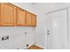 Laundry room features overhead wood cabinets and white door at 10809 W Harmony Ln, Peoria, AZ 85373