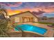 Inviting backyard featuring a sparkling pool, artificial turf and a covered patio at 10809 W Harmony Ln, Peoria, AZ 85373