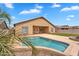 Inviting backyard pool with desert landscaping and a covered patio, perfect for outdoor relaxation and entertaining at 10809 W Harmony Ln, Peoria, AZ 85373