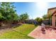 Serene backyard featuring a lush lawn, mature trees, and charming patio seating, perfect for outdoor relaxation at 11429 W Yavapai St, Avondale, AZ 85323