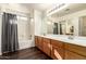 Bathroom features a double vanity, shower over tub and neutral decor at 11429 W Yavapai St, Avondale, AZ 85323