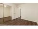 Bright bedroom featuring a ceiling fan, wood-look flooring, and a mirrored closet at 11429 W Yavapai St, Avondale, AZ 85323