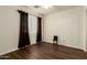 Cozy bedroom featuring dark wood-look floors and sheer curtains for soft, natural light at 11429 W Yavapai St, Avondale, AZ 85323