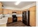 Well-lit kitchen features wooden cabinets, black appliances, and a farmhouse style sink at 11429 W Yavapai St, Avondale, AZ 85323