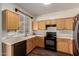 Functional kitchen with wood cabinets, black appliances, light countertops, and wood floors at 11429 W Yavapai St, Avondale, AZ 85323