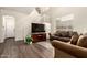 Spacious living room with wood floors, staircase, a large window, and comfortable sofas at 11429 W Yavapai St, Avondale, AZ 85323