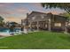 Expansive backyard featuring a sparkling pool, lush lawn, covered patio, and outdoor grill area at 1181 N Dustin Ln, Chandler, AZ 85226
