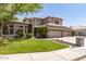 Charming two-story home boasts a lush green lawn, mature trees, and a three-car garage at 1181 N Dustin Ln, Chandler, AZ 85226