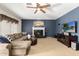 Cozy living room with a fireplace, plush sofa, and a ceiling fan for added comfort at 1181 N Dustin Ln, Chandler, AZ 85226