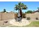 Outdoor dining area with a stone patio, metal table and chairs, and a palm tree under a clear blue sky at 1212 W Vera Ln, Tempe, AZ 85284