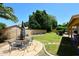 Beautifully landscaped backyard featuring green grass, a stone patio with outdoor furniture, and mature trees providing shade at 1212 W Vera Ln, Tempe, AZ 85284