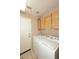 Bright laundry room with white appliances and wooden cabinets above at 1212 W Vera Ln, Tempe, AZ 85284