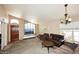Spacious living room featuring plush carpeting, ample natural light, and a decorative chandelier at 1212 W Vera Ln, Tempe, AZ 85284