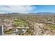 A high-angle aerial view showcases a neighborhood surrounded by desert vegetation, a golf course, and distant mountains at 12381 S 182Nd Dr, Goodyear, AZ 85338