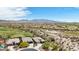 A high-angle aerial view shows the neighborhood, golf course, desert vegetation, and mountain range in the distance at 12381 S 182Nd Dr, Goodyear, AZ 85338