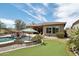 Backyard features a pool, putting green, landscaping, and a covered patio with outdoor seating at 12381 S 182Nd Dr, Goodyear, AZ 85338