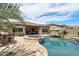 Lush backyard features a pool, spa, built-in grill, desert landscaping, and an outdoor bar at 12381 S 182Nd Dr, Goodyear, AZ 85338