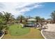 Backyard featuring a putting green, a swimming pool and spa, a built-in grill, and desert landscaping at 12381 S 182Nd Dr, Goodyear, AZ 85338