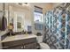 Well-lit bathroom featuring a single sink vanity, blue decorative tile accents, and a stylish shower curtain at 12381 S 182Nd Dr, Goodyear, AZ 85338