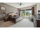 Comfortable primary bedroom features large windows with outside views, soft carpet, ceiling fan, and neutral walls at 12381 S 182Nd Dr, Goodyear, AZ 85338