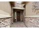 Warm entryway features beautiful stone accents and a welcoming wooden door with decorative wreath at 12381 S 182Nd Dr, Goodyear, AZ 85338
