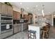 Modern kitchen featuring stainless steel appliances, granite countertops, large island with bar stool seating, and ample cabinet space at 12381 S 182Nd Dr, Goodyear, AZ 85338