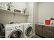 Laundry area with front loading machines, overhead storage, and countertops for folding and supplies at 12381 S 182Nd Dr, Goodyear, AZ 85338