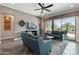 Cozy living room features tile floors, a ceiling fan, plush seating, and large windows for natural light at 12381 S 182Nd Dr, Goodyear, AZ 85338