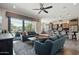 Bright living room features a modern ceiling fan, a comfortable seating arrangement, and outdoor patio access at 12381 S 182Nd Dr, Goodyear, AZ 85338