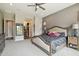 Cozy main bedroom showcases a ceiling fan, carpeted floors, and side tables with lamps on each side of the bed at 12381 S 182Nd Dr, Goodyear, AZ 85338
