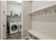 Mud room features a bench, hooks, overhead storage, and a laundry room with front loading machines at 12381 S 182Nd Dr, Goodyear, AZ 85338