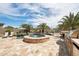 An outdoor kitchen and bbq island overlooking a custom travertine pool and raised spa with palm trees at 12381 S 182Nd Dr, Goodyear, AZ 85338
