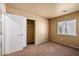 Neutral bedroom features closet, carpet, and a window at 12621 W Willow Ave, El Mirage, AZ 85335
