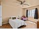 A charming bedroom features wood floors, a ceiling fan, and a pastel chair at 12621 W Willow Ave, El Mirage, AZ 85335