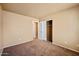 Neutral bedroom features closet, carpet, and a window at 12621 W Willow Ave, El Mirage, AZ 85335