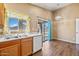 A brightly lit kitchen features wood floors, a stainless steel sink, and sliding glass doors at 12621 W Willow Ave, El Mirage, AZ 85335