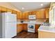 Efficient kitchen with wood cabinets, white appliances, and lots of natural light at 12621 W Willow Ave, El Mirage, AZ 85335