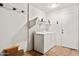 Bright laundry room with washer, dryer, and storage shelf for optimal convenience at 12621 W Willow Ave, El Mirage, AZ 85335